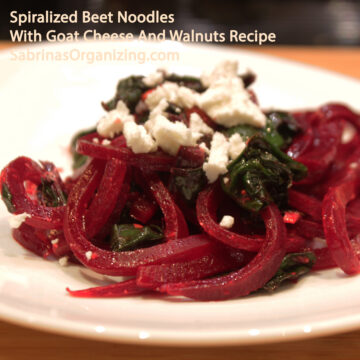 a white plate on a wood table - with the beet noodle dish on it. title of the post is at the top - Square image
