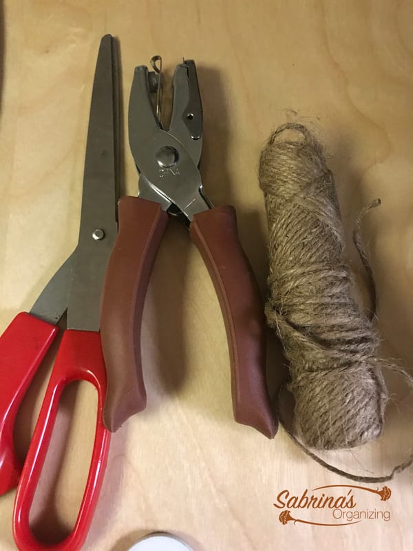 some of the supplies used for this project scissors hole puncher and twine