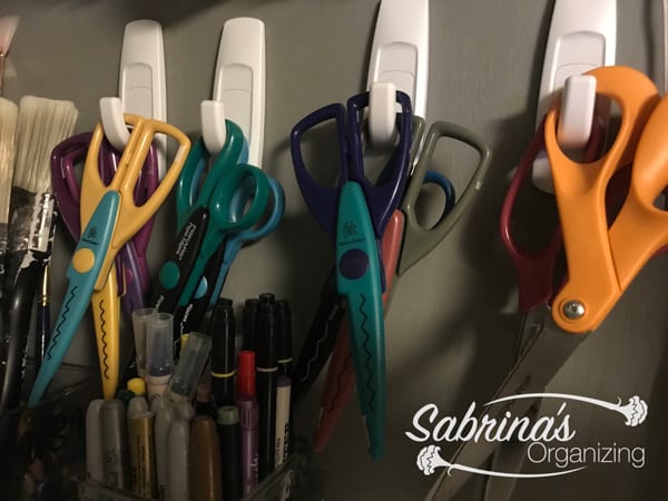 Hang scissors on the cabinet wall with hooks