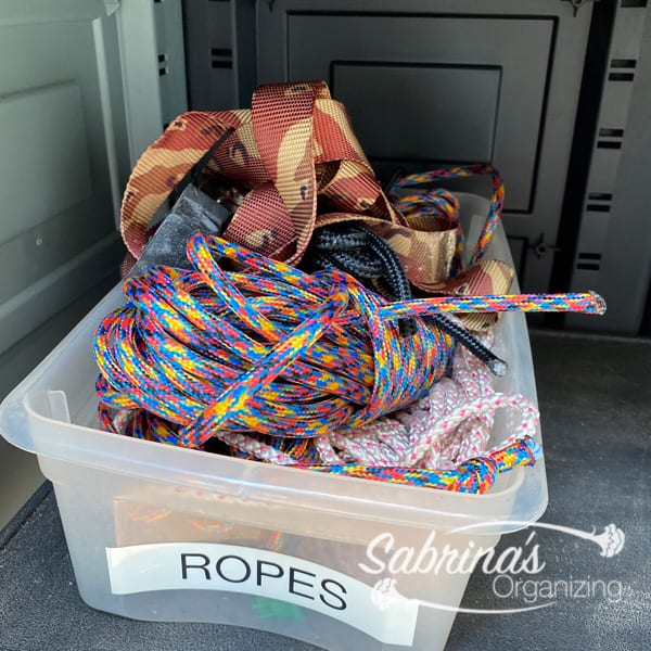 Label the tarp ropes in a shoebox container. 