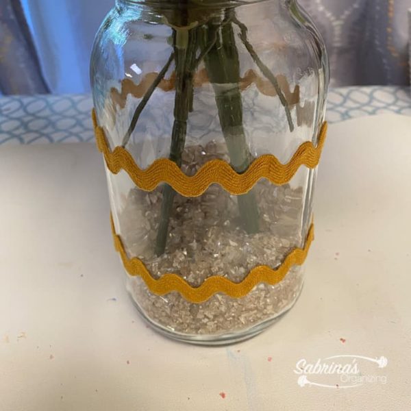 Add the broken mirror pieces to the inside of the mason jar