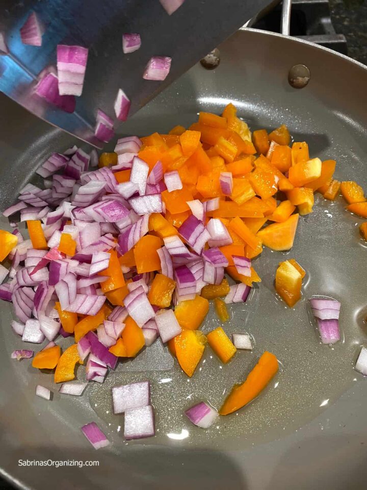 Add peppers and onions to skillet to cook