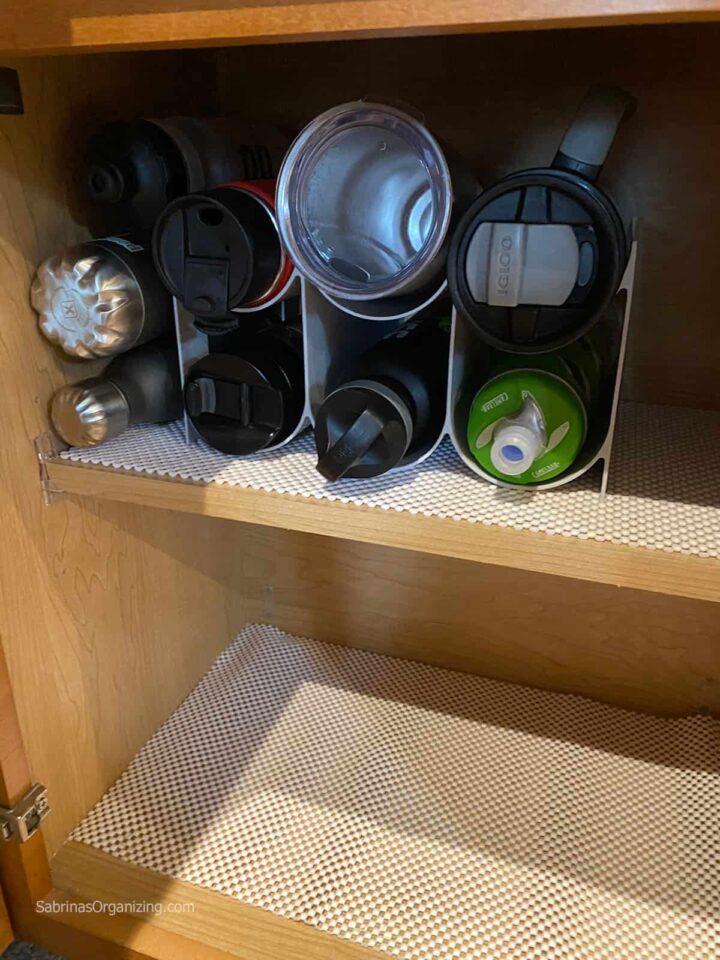 Add the water bottles to the water bottle organizer
