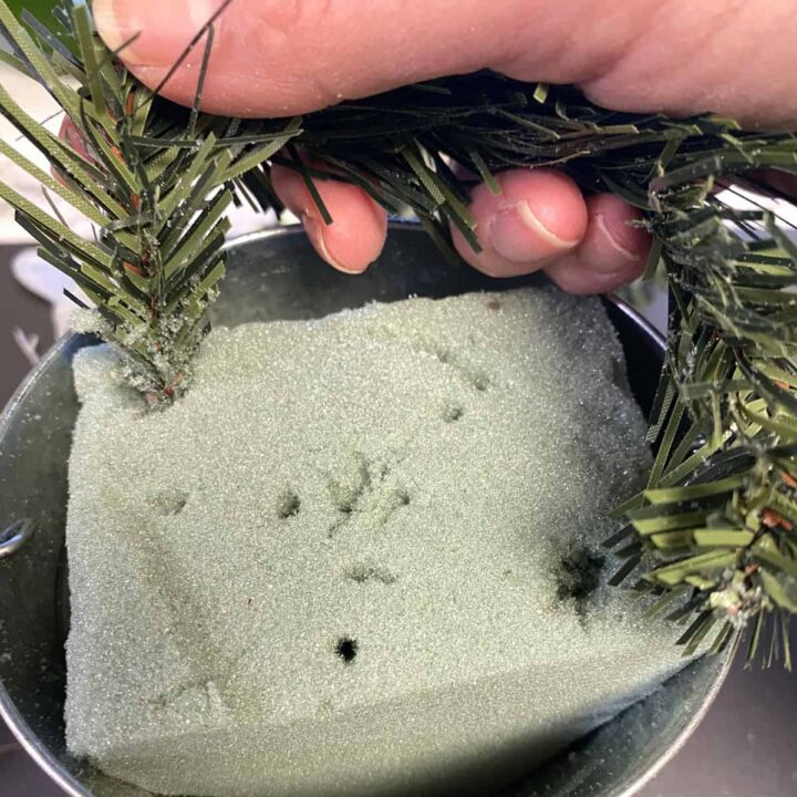 press the faux pine needles into the foam and wrap around the bucket