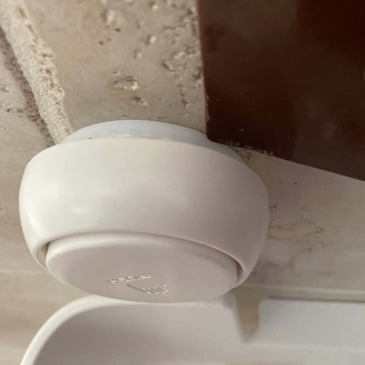 Remove the Shower Guest Caddy from the wall with a plastic scraper
