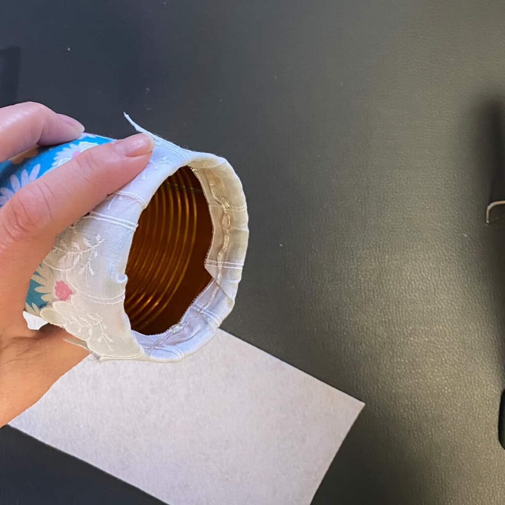 Add hot glue to the inside of the can to adhere the felt to the inside of the can.