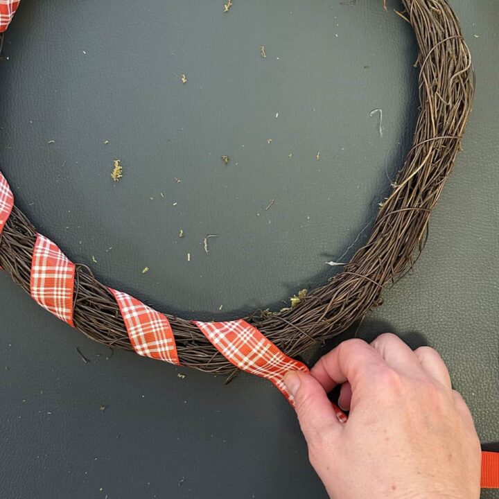 Keep wrapping the ribbon around and adding hot glue to the wreath