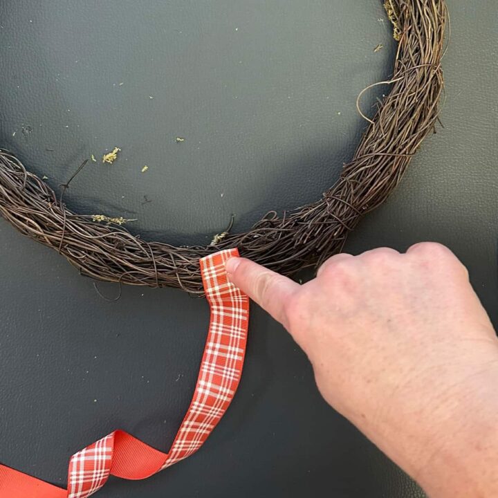 Using hot glue add the ribbon to wreath