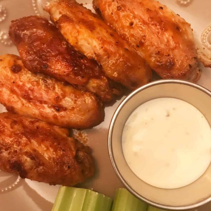 Buffalo Chicken Wings on a plate with celery and blue cheese dip