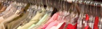 a person's hands moving hanging clothes in the closet - square image - title at the top middle
