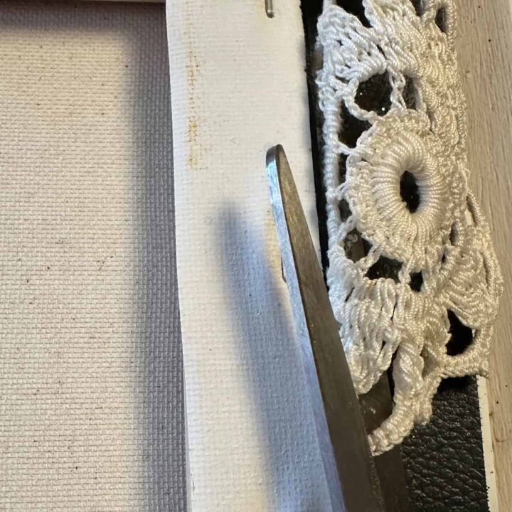 Cut excess doily material of the back of the canvas