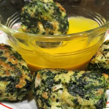 Best Spinach Balls Recipe on a plate and honey mustard in a glass bowl.