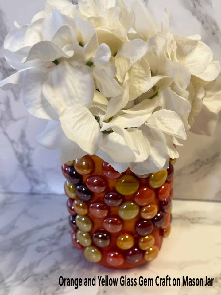 title and image mason jar with gems and paint and white faux flowers