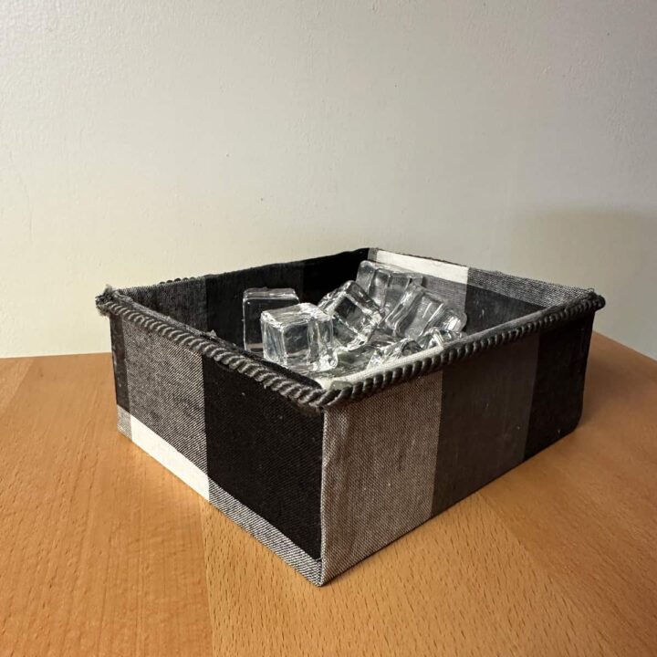 Box with rope and fabric on a table with a wall background square image