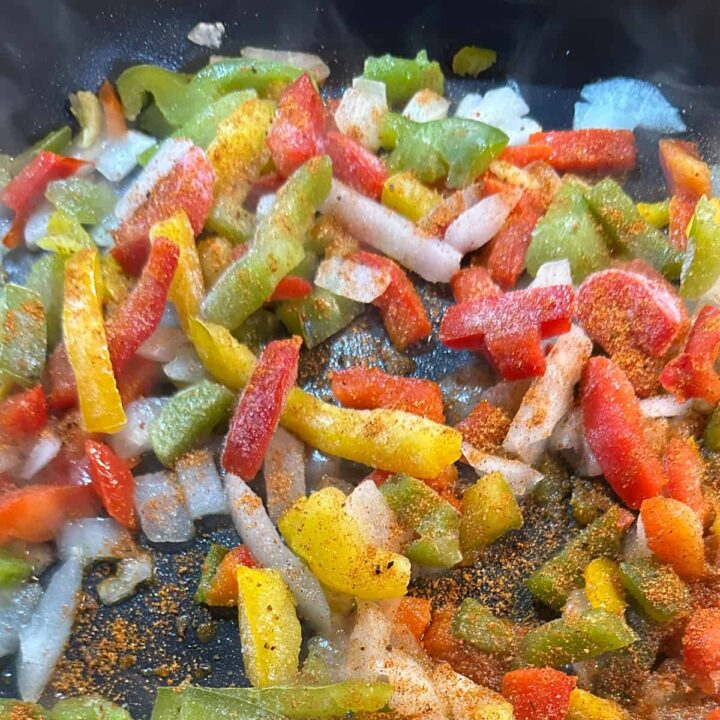 cooked peppers and onions in skillet