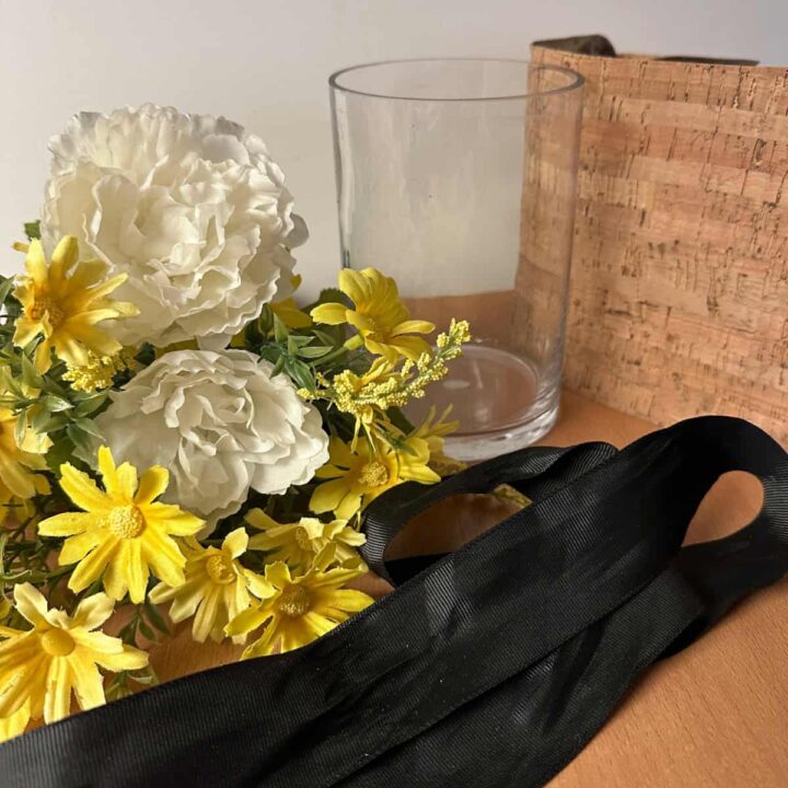 ribbon black, glass vase, cork fabric, and silk yellow flowers. 