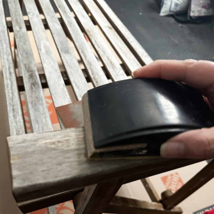 Bench with a sanding paper and hand holding it