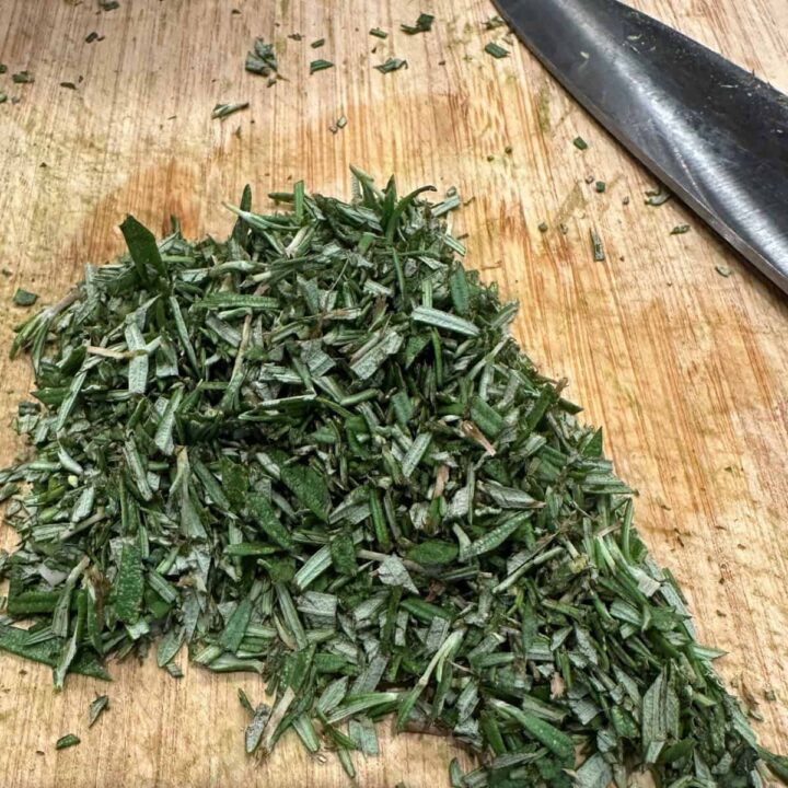 Rosemary chopped on cutting board - square image