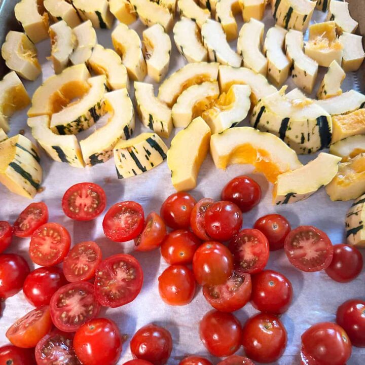 cut tomatoes at the bottom of the baking sheet and squash at the top - square image