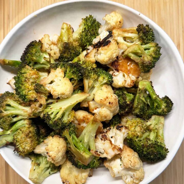 Broccoli and cauliflower in a bowl on a cutting board on square size image