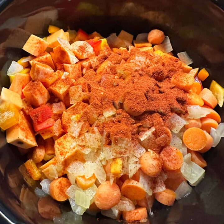 paprika poured over vegetables in the slow cooker - square image