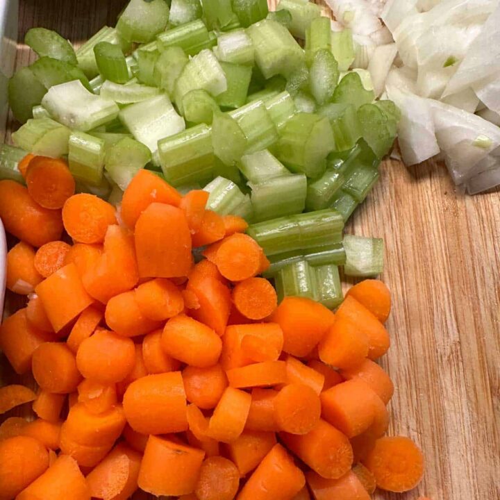 add carrots, celery, and onions on cutting board - square image
