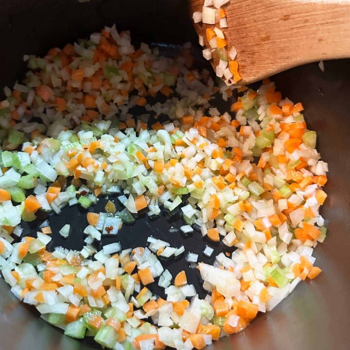 chopped finely Onion carrot and celery in a sauce pan - square image