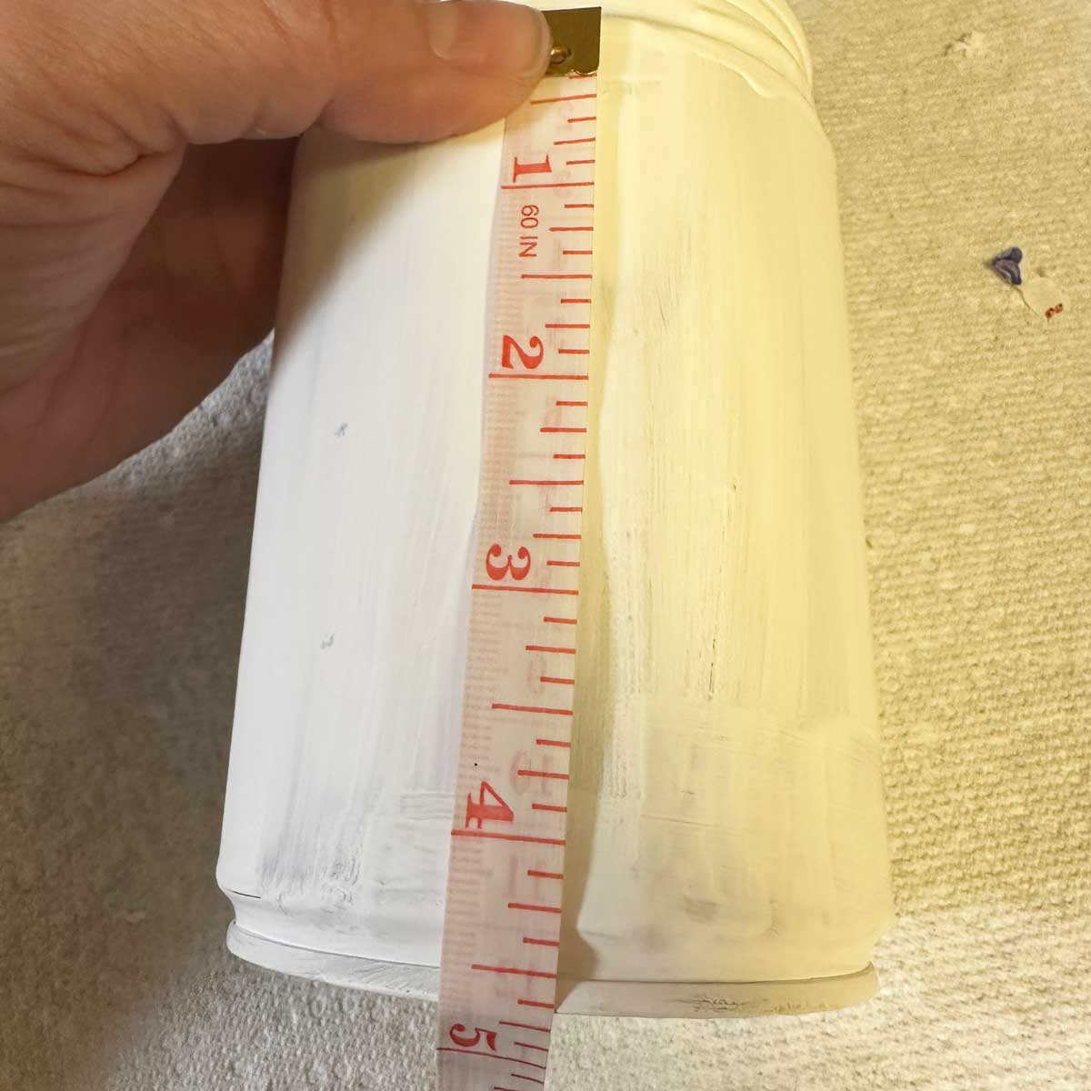 tape measure that read 4.5 inches over painted can - square image