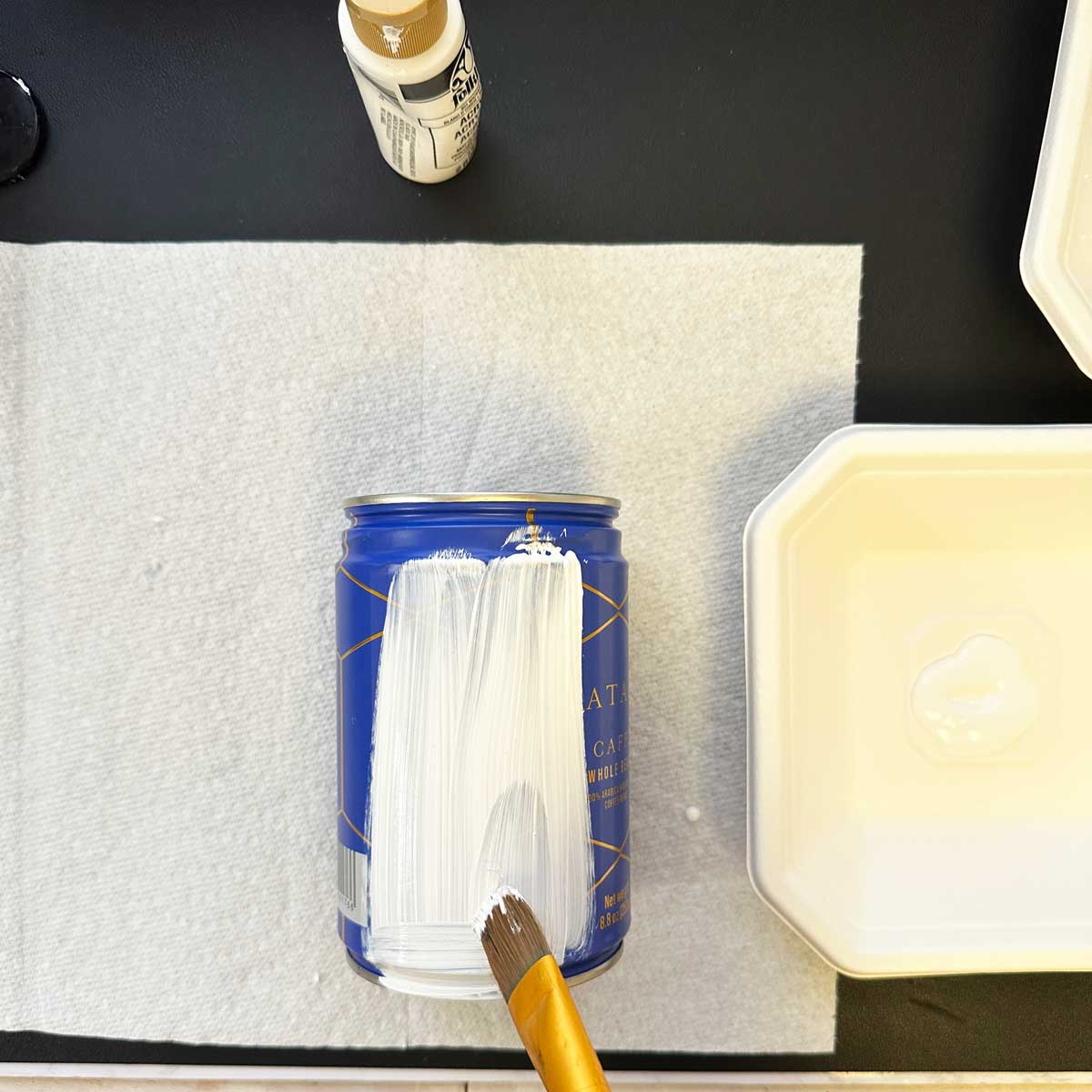 painted lines and a brush showing the coffee can being painted white- square image