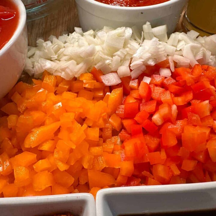 peppers and onions cut up on a cuttingboard