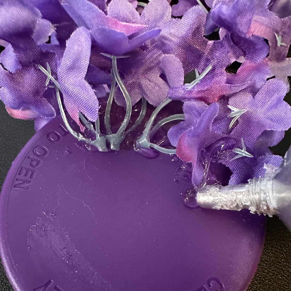 Remove the stems from faux flower boutique and glue with clear glue to lid - square image
