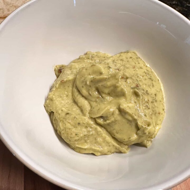 finished avocado crema in a white bowl - square image