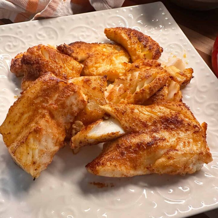a pile of cooked seasoned cod on a plate.