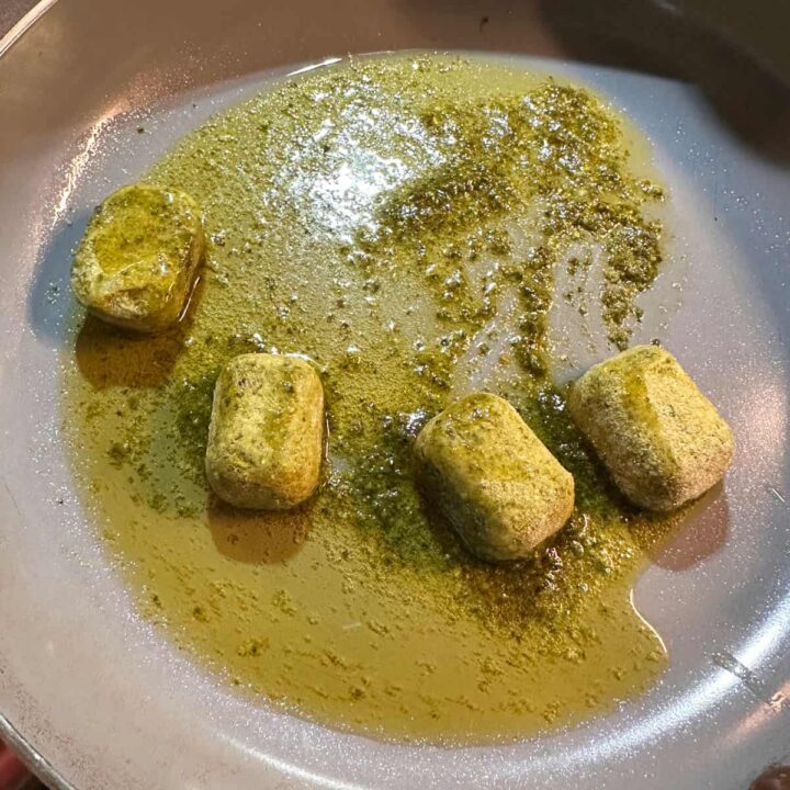 Basil pesto bombs melting in a skillet