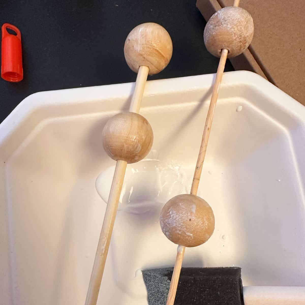 add gold foil glue to the wooden beads that are on skewers - square image